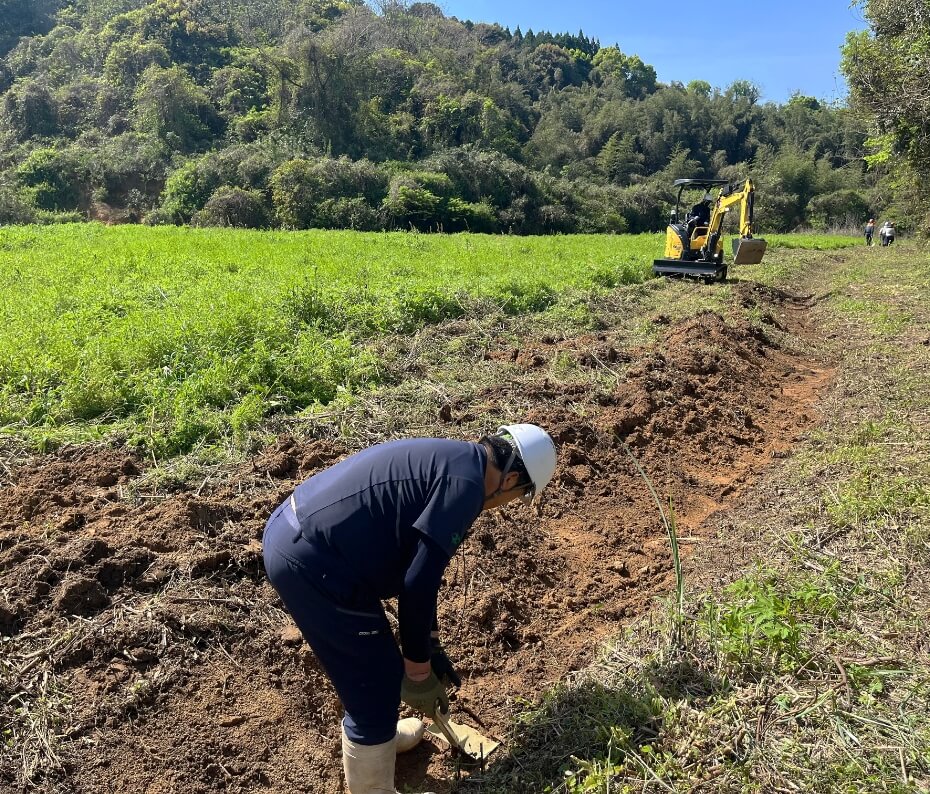 重機が入った造成現場で地面を整える作業員